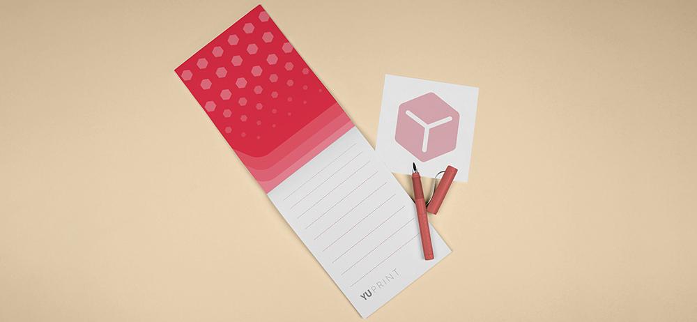Bloc de notas Yuprint desplegado con diseño en tonos rojos, ideal para listas, ideas y planificación.