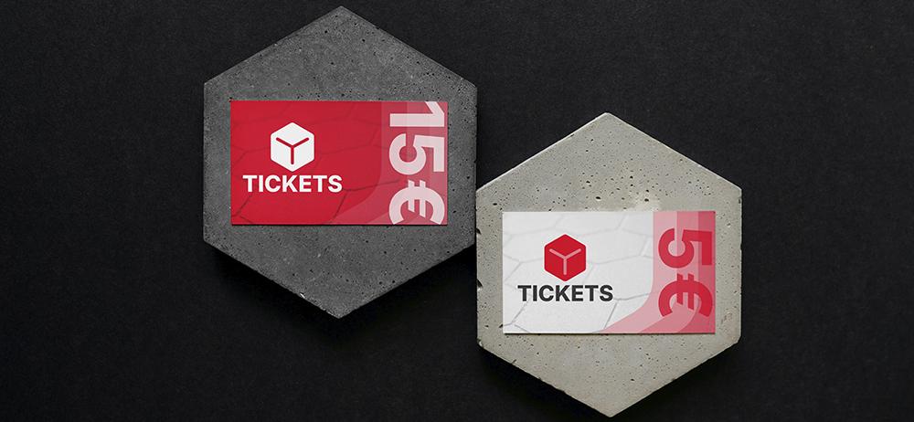 Tickets impresos YUPrint en soportes de cemento, diseños rojo y blanco con precios visibles para eventos.