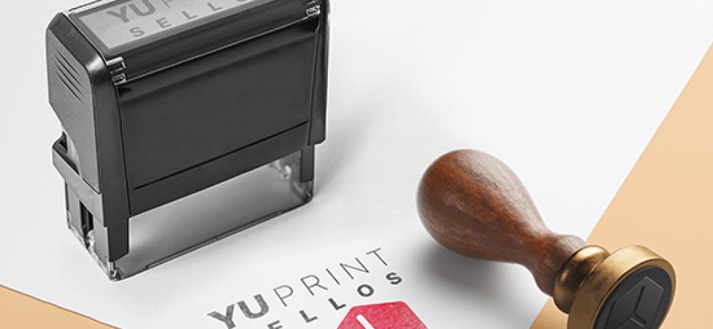 Sello automático y sello de madera YUPrint estampando logo personalizado, ideal para documentos y branding profesional.