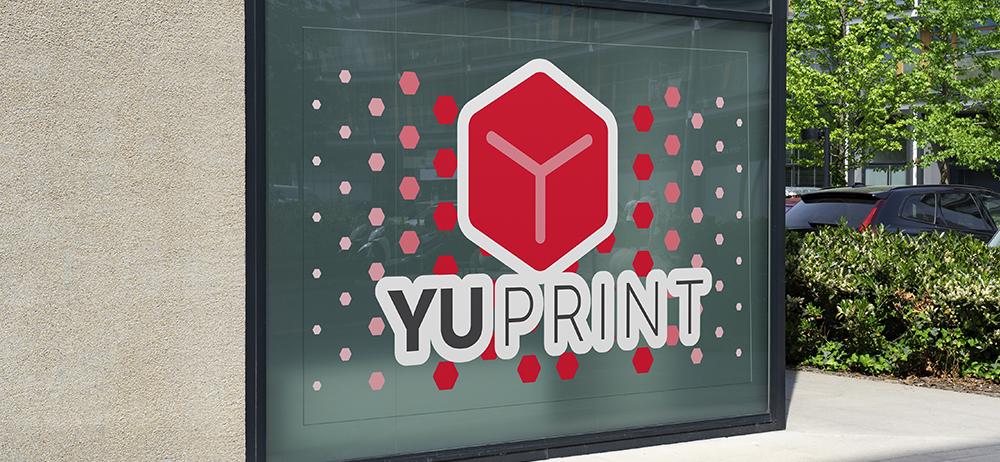 Vinilo transparente con logotipo YUPRINT aplicado en escaparate para decoración comercial.